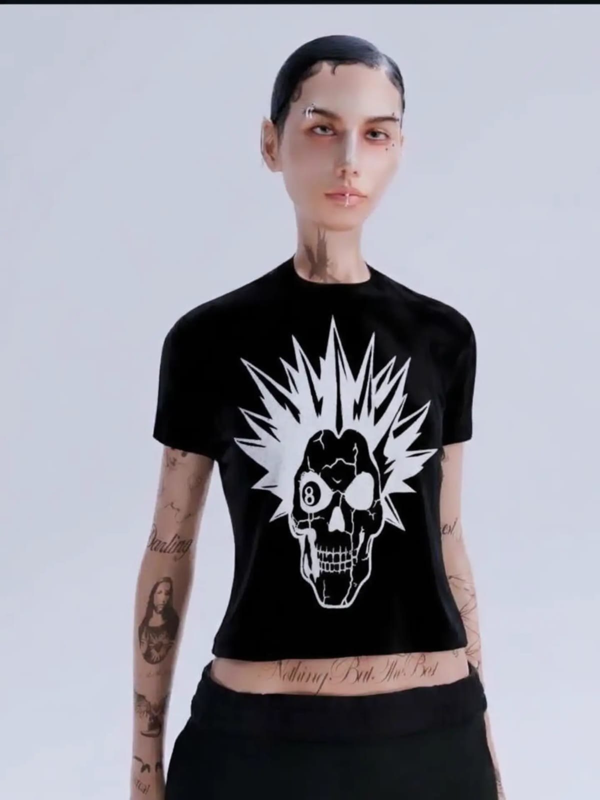 Mona wearing the black Night Dweller Baby Tee: the white vintage Skele print, a skull with a spiked mohawk and an 8-ball eye, on the front